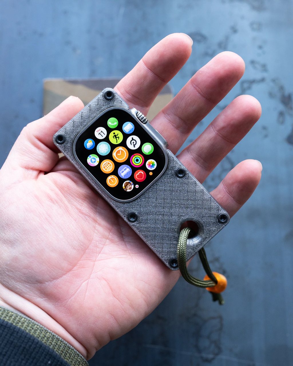 The Fob case with an Apple Watch inside, resting in an open palm